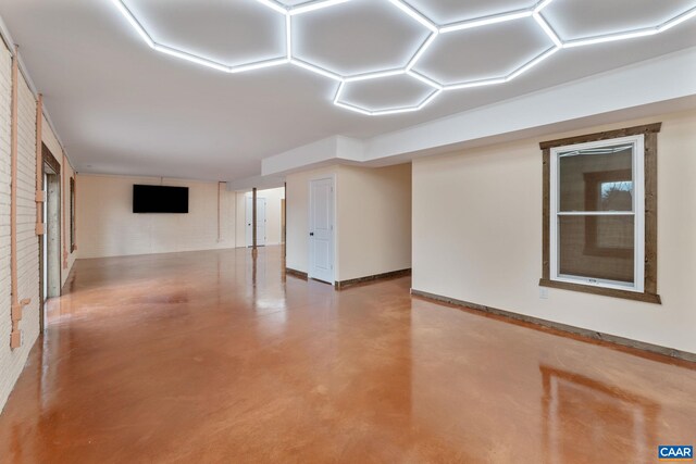 empty room featuring concrete floors and brick wall