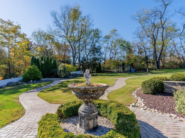 view of property's community featuring a yard and a playground