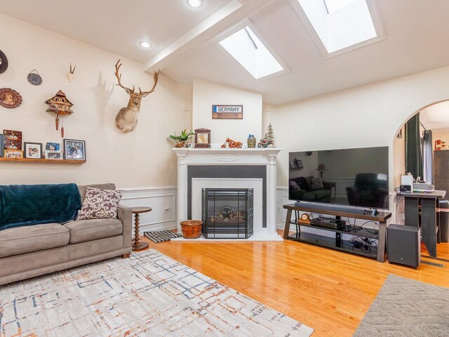 living room featuring wood-type flooring and vaulted ceiling