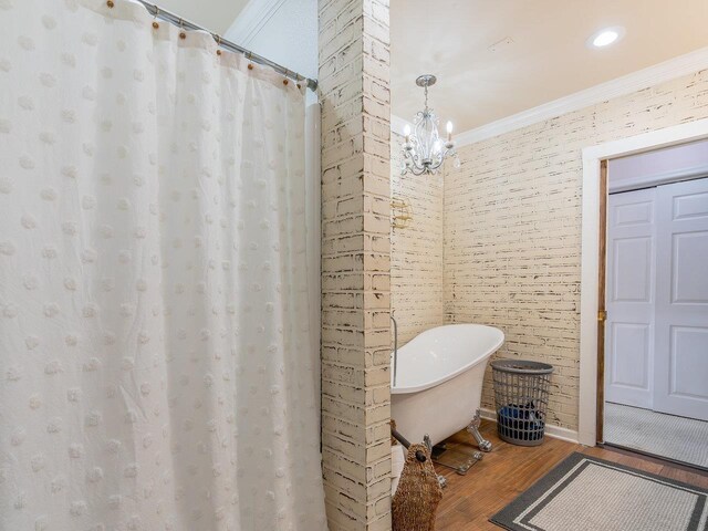 bathroom featuring hardwood / wood-style flooring, crown molding, and a chandelier