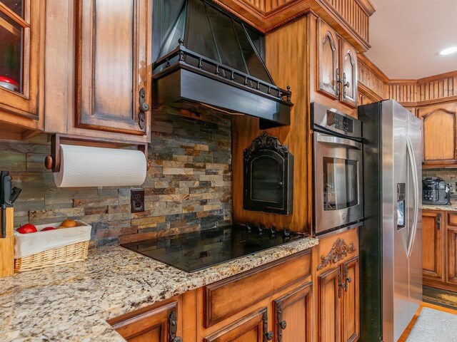 kitchen with extractor fan, backsplash, light stone countertops, and appliances with stainless steel finishes