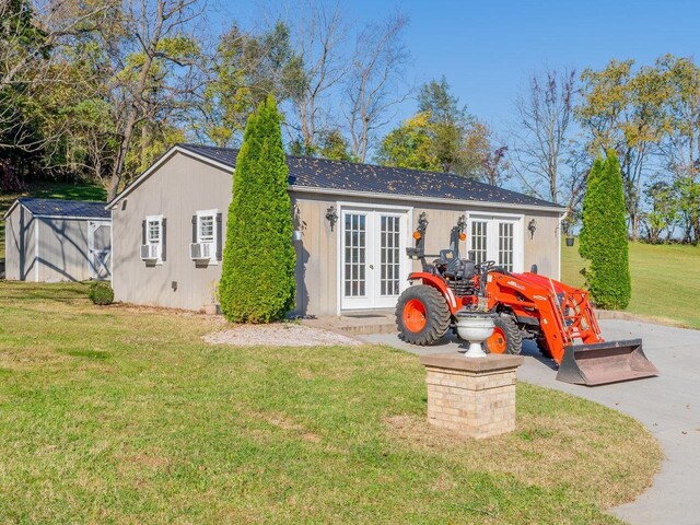 back of property with french doors, an outdoor structure, and a lawn