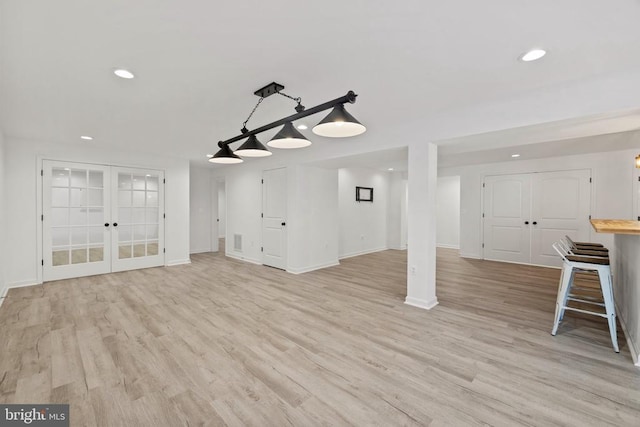 unfurnished living room with recessed lighting, french doors, baseboards, and light wood finished floors