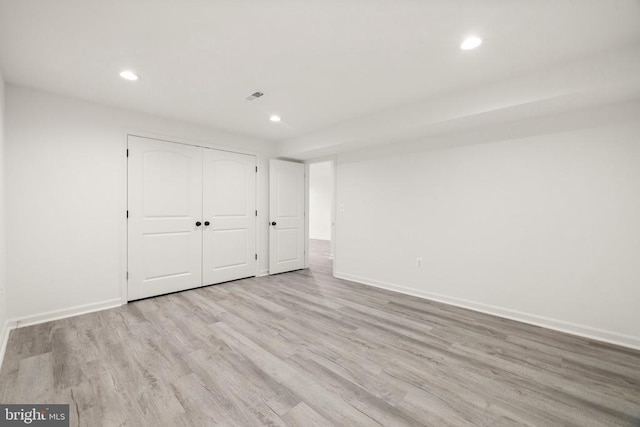 unfurnished bedroom featuring recessed lighting, a closet, baseboards, and wood finished floors