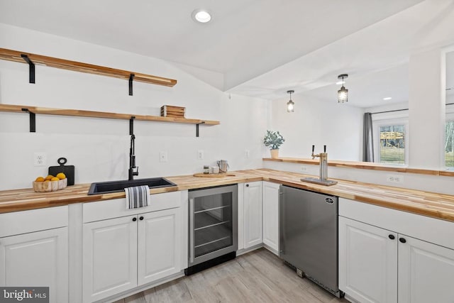 kitchen with open shelves, refrigerator, a sink, wine cooler, and wood counters