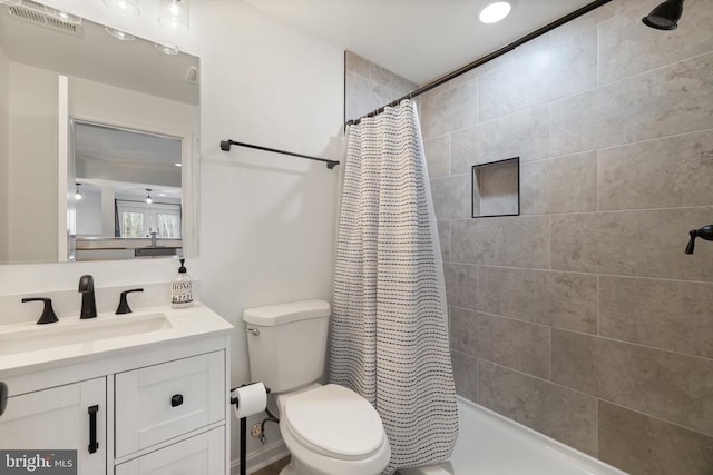 bathroom featuring vanity, a shower with shower curtain, toilet, and visible vents