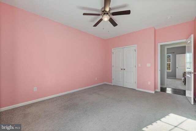 unfurnished bedroom featuring carpet flooring, a ceiling fan, baseboards, and a closet