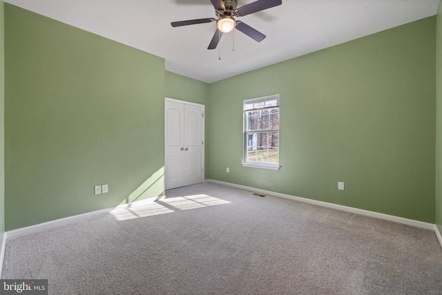 spare room with carpet flooring, ceiling fan, and baseboards