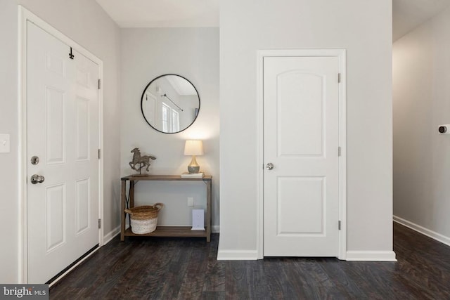 foyer featuring baseboards and wood finished floors