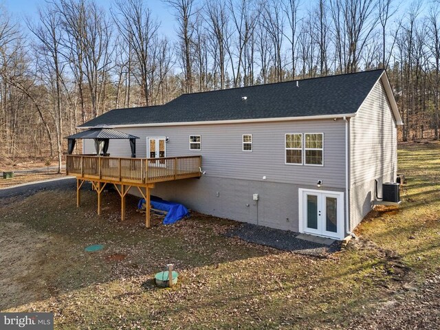 rear view of property featuring a wooden deck, a shingled roof, a gazebo, french doors, and central air condition unit