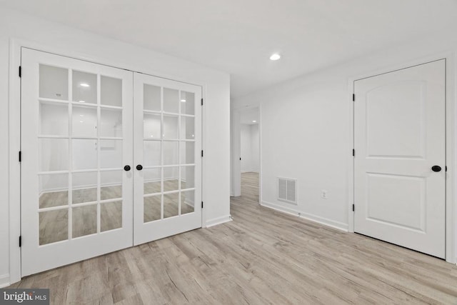 unfurnished bedroom featuring wood finished floors, visible vents, baseboards, recessed lighting, and french doors