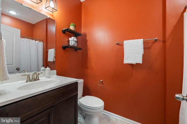 full bathroom featuring toilet, vanity, and baseboards