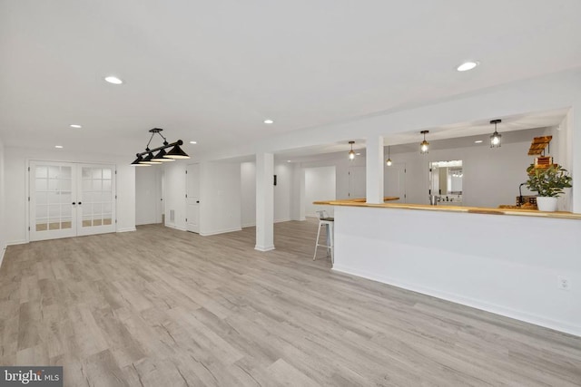 unfurnished living room featuring recessed lighting, french doors, light wood-type flooring, and baseboards