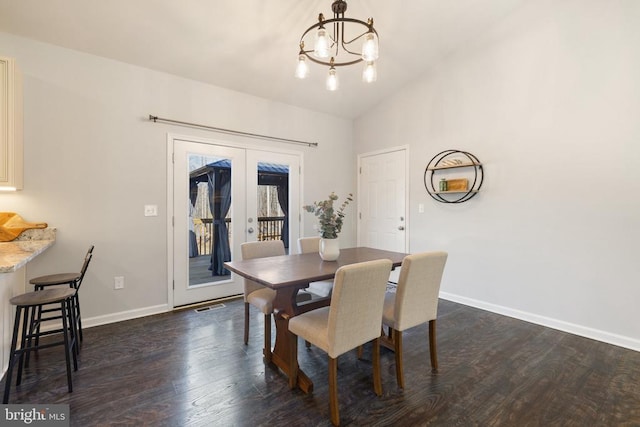 dining room with baseboards, lofted ceiling, dark wood-type flooring, french doors, and a chandelier