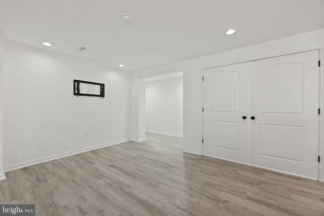 empty room with recessed lighting, light wood-style floors, and baseboards