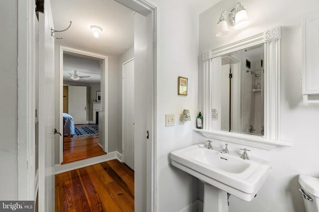 full bathroom with a shower, a sink, wood finished floors, and toilet