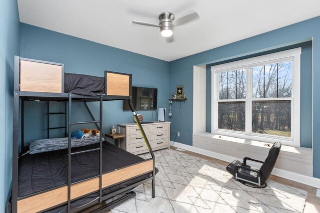 bedroom with ceiling fan, light hardwood / wood-style floors, and multiple windows