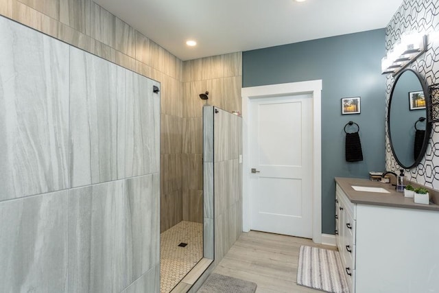 bathroom featuring vanity, hardwood / wood-style flooring, and tiled shower