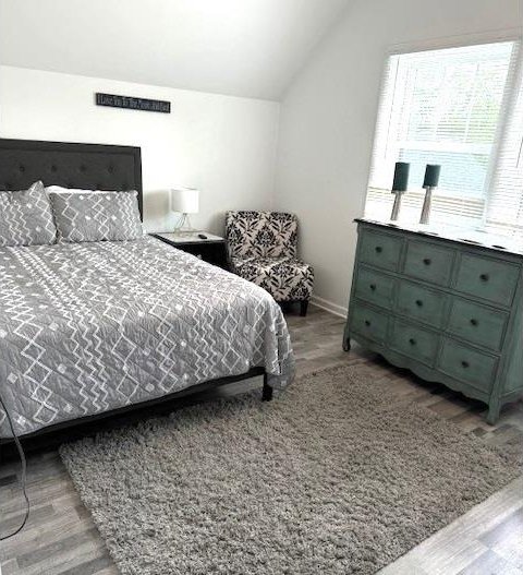 bedroom with lofted ceiling and light hardwood / wood-style floors