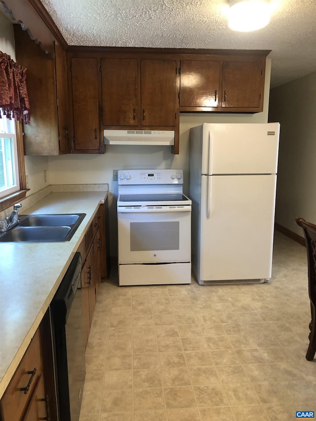 kitchen with sink, white appliances, and a textured ceiling