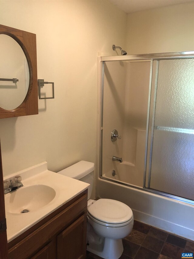 full bathroom with vanity, toilet, and combined bath / shower with glass door