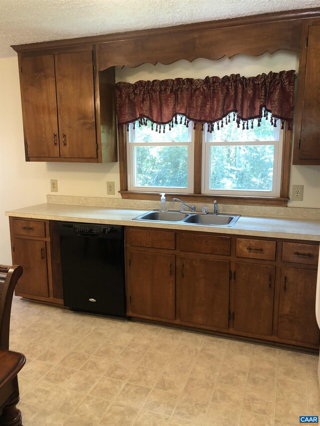 kitchen featuring sink, dark brown cabinets, and black dishwasher