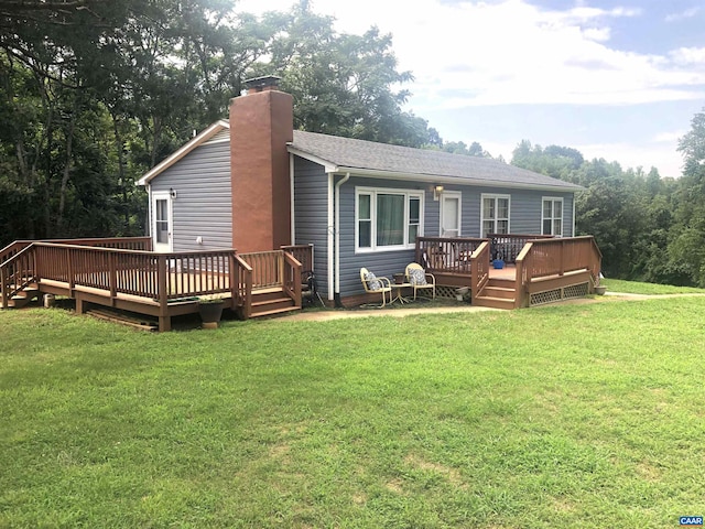 rear view of house with a deck and a lawn