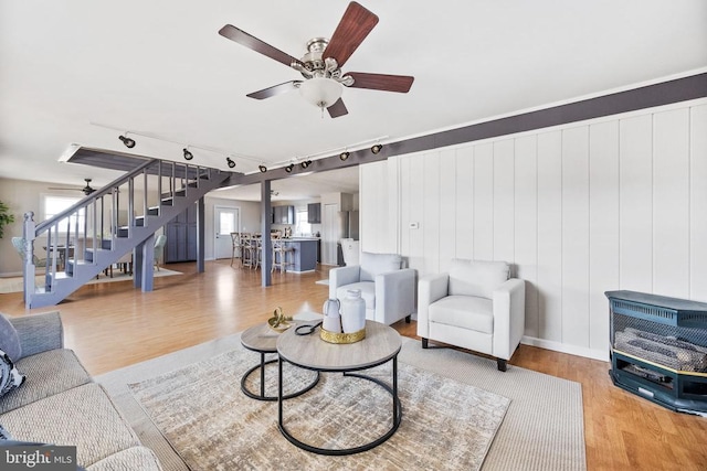 living room with wood-type flooring and ceiling fan