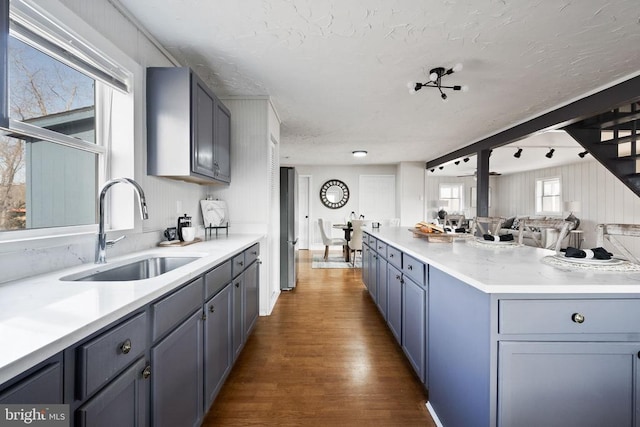 kitchen with sink, dark wood-type flooring, stainless steel fridge, and gray cabinets