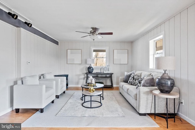 living room featuring wood-type flooring and ceiling fan