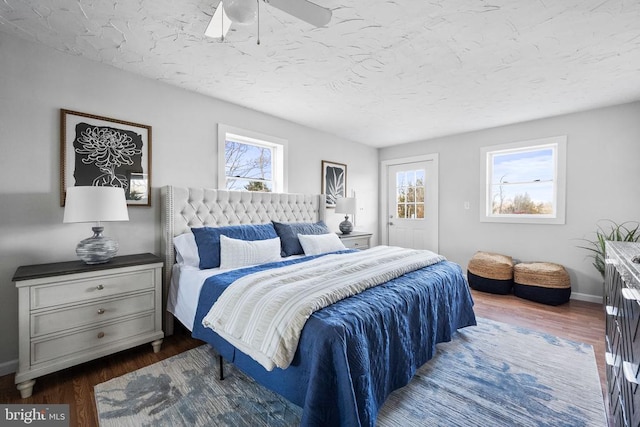 bedroom with multiple windows, dark hardwood / wood-style floors, and ceiling fan