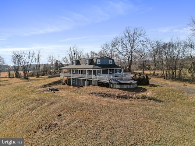 view of front of house featuring a deck, a front lawn, and a rural view