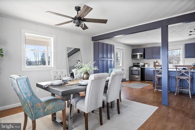 dining area featuring dark hardwood / wood-style flooring, ornamental molding, and ceiling fan