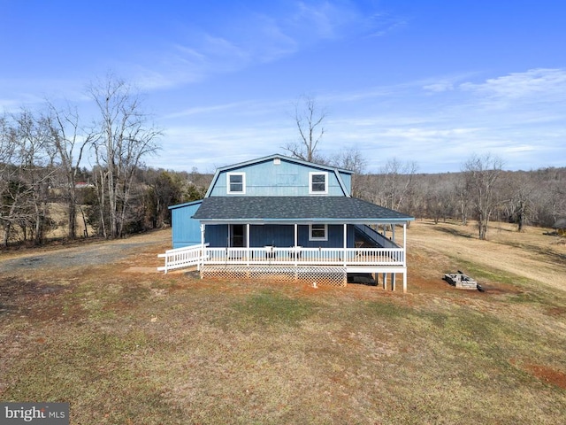 farmhouse featuring a deck and a front lawn