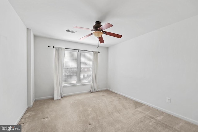 carpeted empty room featuring baseboards, visible vents, and ceiling fan