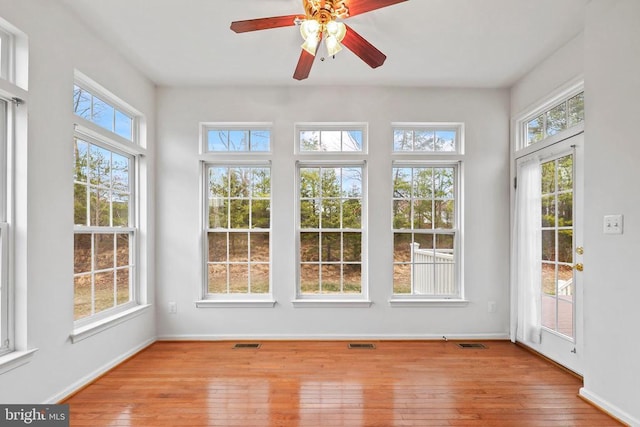 unfurnished sunroom with ceiling fan and visible vents