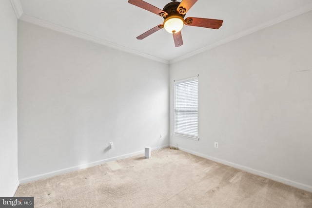 carpeted empty room featuring ornamental molding, baseboards, and a ceiling fan