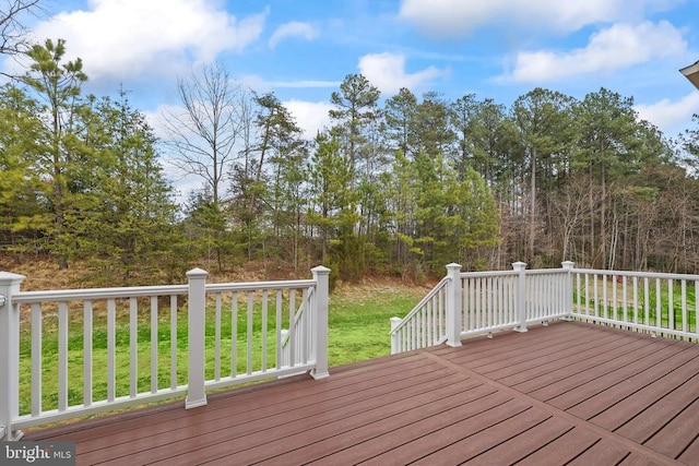 wooden deck featuring a lawn