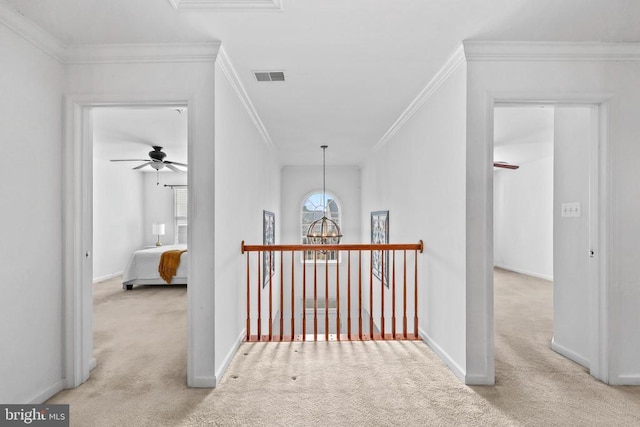 hallway with crown molding, baseboards, a chandelier, and carpet flooring