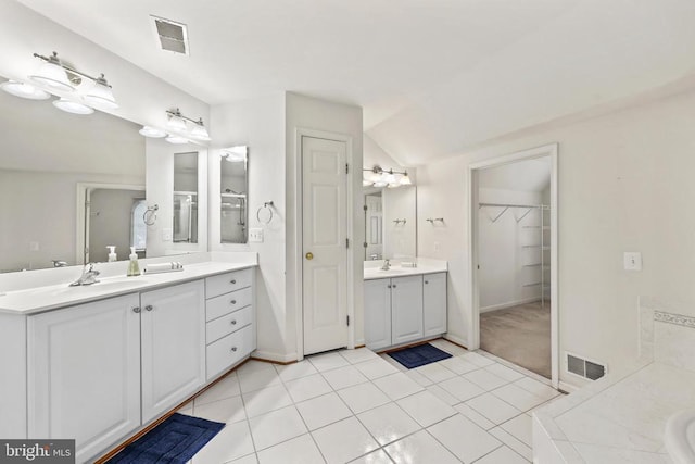 bathroom featuring tile patterned flooring, two vanities, a sink, and visible vents