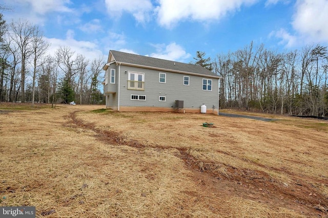 back of house featuring central AC and a yard