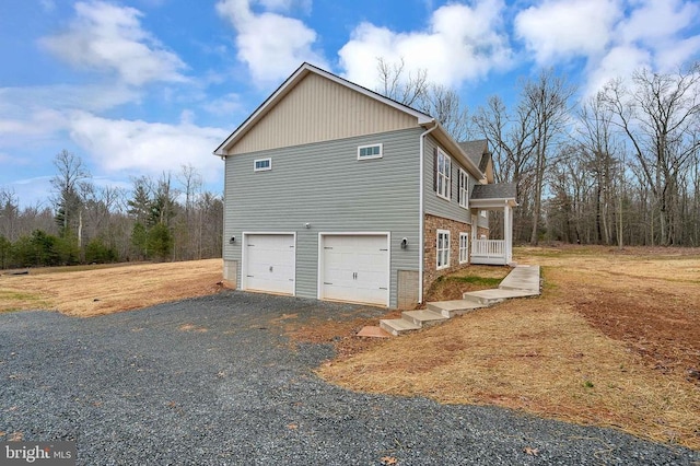 view of home's exterior with a garage, brick siding, and aphalt driveway