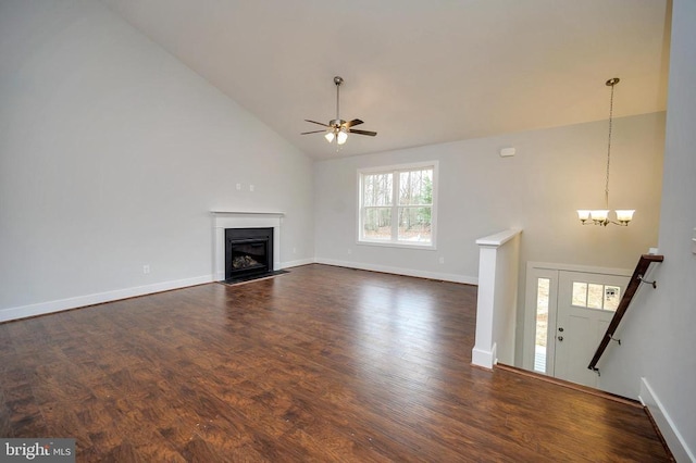 unfurnished living room featuring high vaulted ceiling, ceiling fan with notable chandelier, and dark hardwood / wood-style flooring