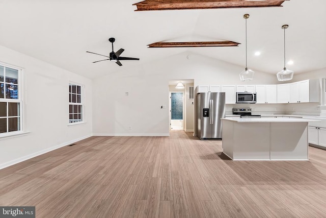 kitchen featuring appliances with stainless steel finishes, light hardwood / wood-style floors, white cabinets, a kitchen island, and decorative light fixtures