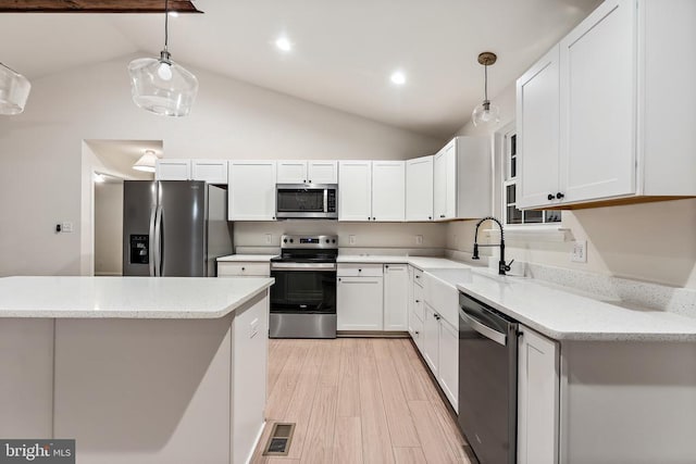 kitchen featuring stainless steel appliances, light stone countertops, pendant lighting, and white cabinets