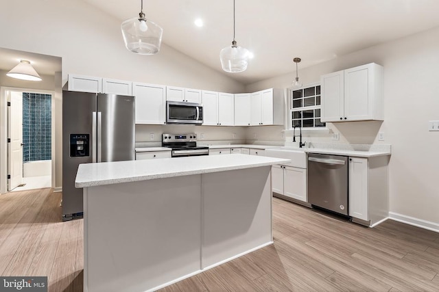 kitchen featuring sink, stainless steel appliances, white cabinets, and a kitchen island