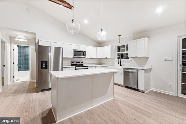 kitchen featuring pendant lighting, light hardwood / wood-style flooring, white cabinetry, stainless steel appliances, and a center island