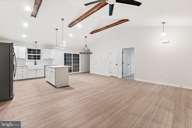 kitchen with pendant lighting, white cabinetry, stainless steel fridge, and a center island