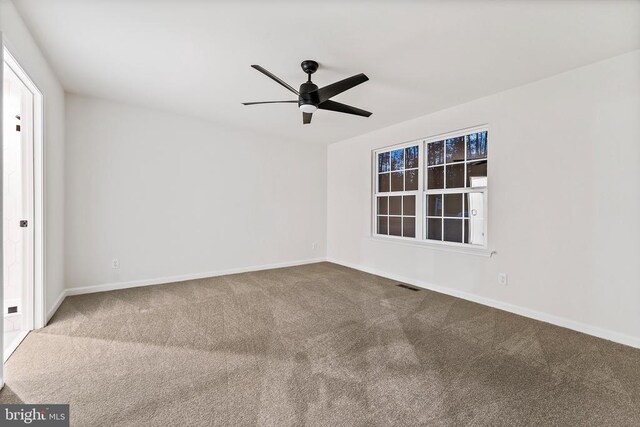 unfurnished room with ceiling fan and carpet