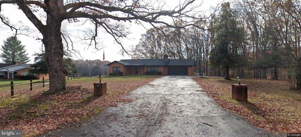 ranch-style house with a garage, aphalt driveway, a chimney, and fence